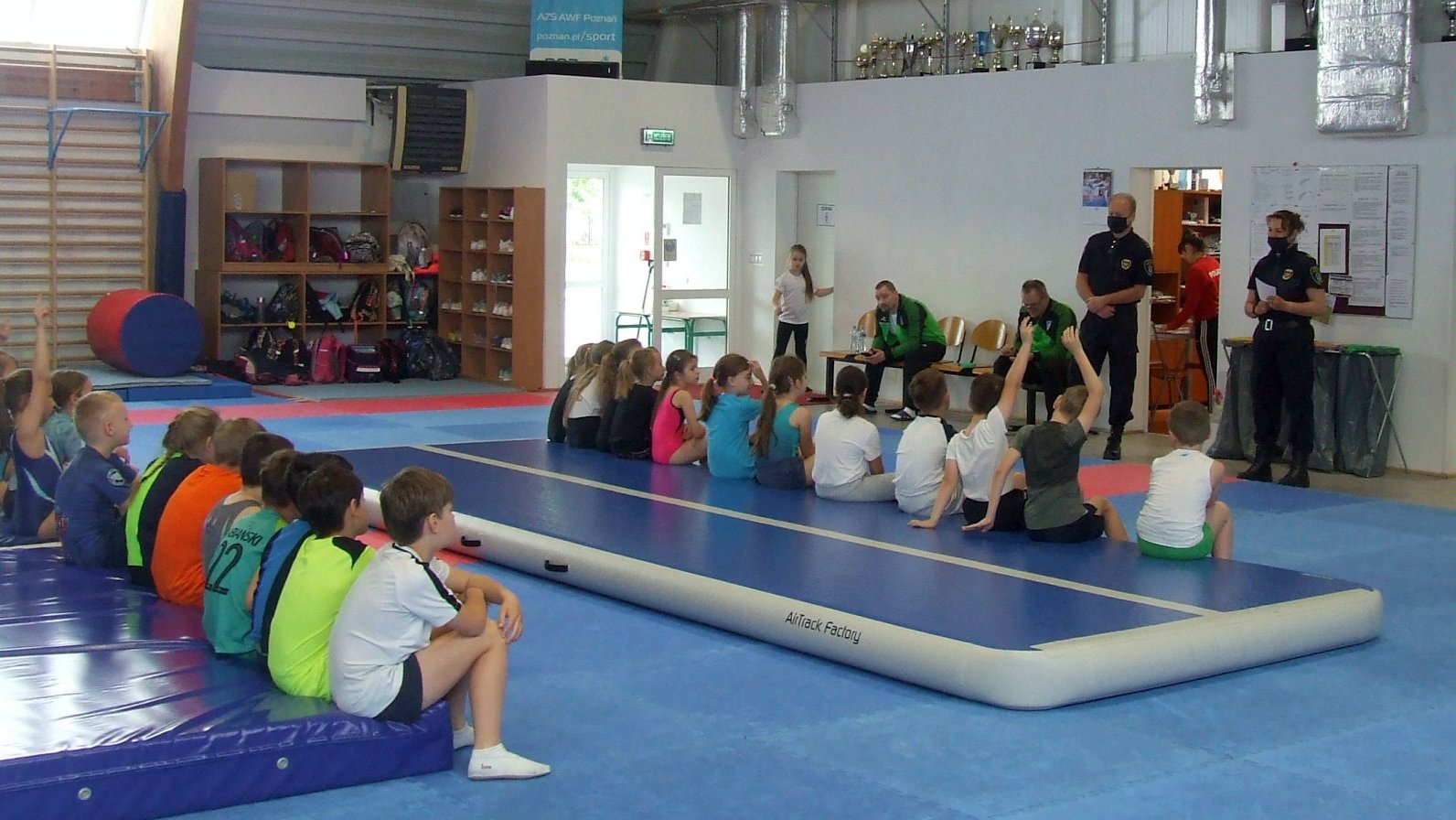 Spotkanie straży miejskej z dziećmi na sali gimnastycznej