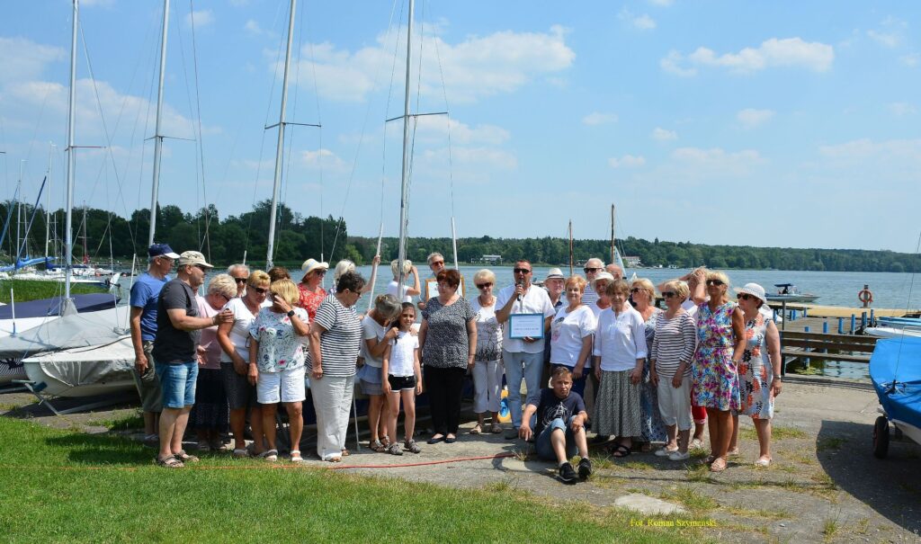 Na zdjęciu członkowie miejskiej RAdy Seniorów na tle jeziora Kierskiego i żagłowek