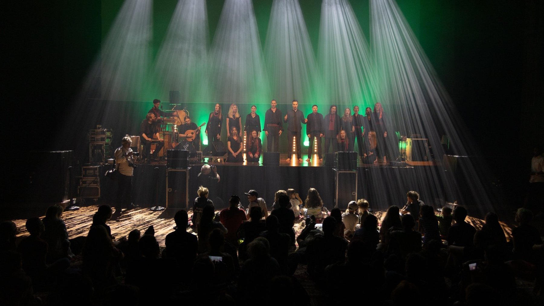 Koncert podczas festiwalu Ethno Port w Centrum Kultury Zamek w Poznaniu; na scenie występuje zespół wokalno-instrumentalny, przed którym siedzi publiczność.